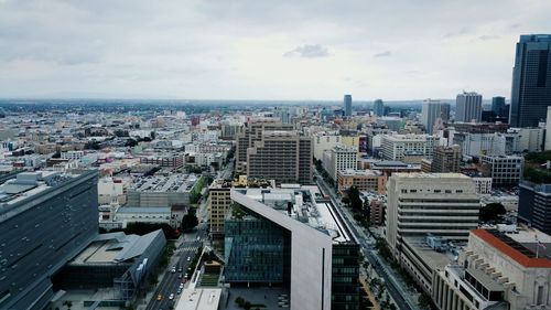 View of cityscape against cloudy sky