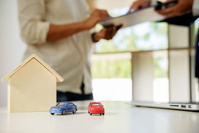 Close-up of toy cars with model home on table