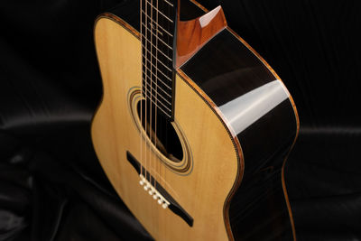 Close-up of guitar on bed