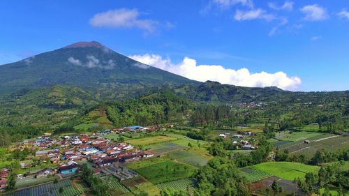 High angle view of agricultural field and houses against sky