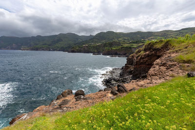 Scenic view of sea and mountains against sky