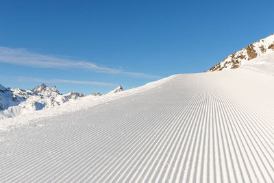 Scenic view of snowcapped mountains against blue sky