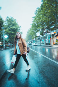 Full length of woman walking on street in city