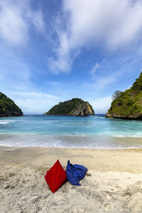 Deck chairs on beach against sky