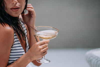 Midsection of a woman drinking glass