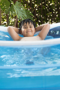 Portrait of a boy playing in the inflatable pool at his home. cool summer activities. 