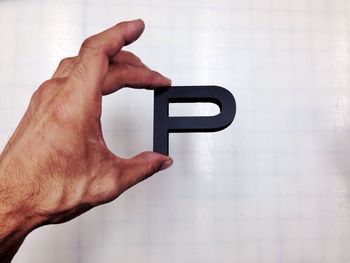 Close-up of male hand holding letter p