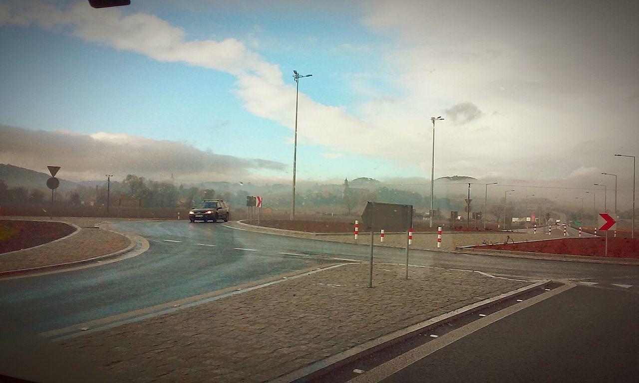 transportation, road, sky, road marking, car, mode of transport, land vehicle, street, street light, cloud - sky, on the move, the way forward, travel, highway, cloudy, outdoors, city, no people, motion, day