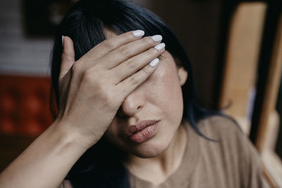 Mid adult woman covering eyes with hands