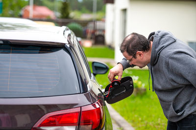 Side view of man holding car