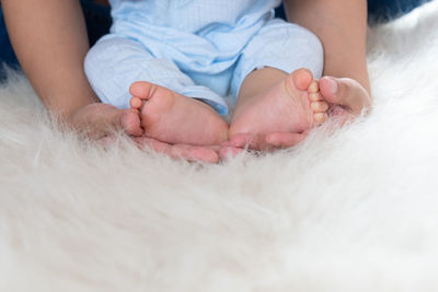 Midsection of baby lying on bed