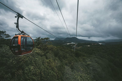 Overhead cable car over mountains against sky