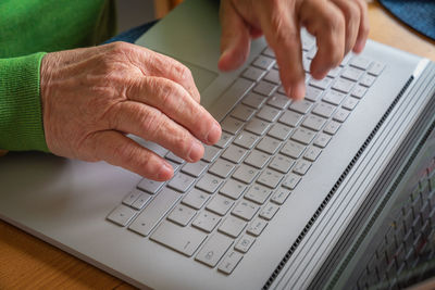 Midsection of person using laptop on table