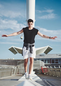 Full length of young man standing against sky