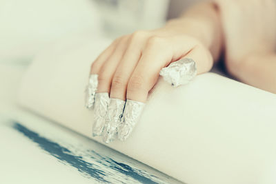 Close-up of woman fingers with wrapped in silver foil 