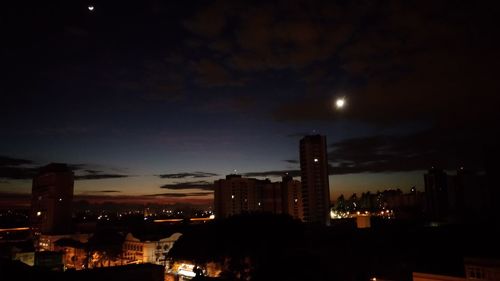 Illuminated cityscape against sky at night