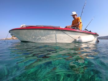 Portrait of senior man on a boat with clear sea and blue sky in background