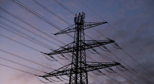 Low angle view of electricity pylon against sky