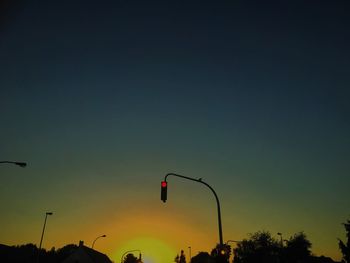 Silhouette of lights against sky at sunset