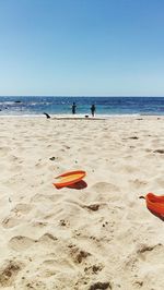 Deck chairs on beach against clear sky