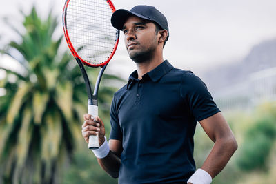 Midsection of man playing tennis