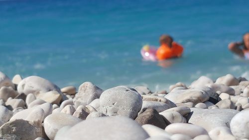 Close-up of pebbles on beach against sky