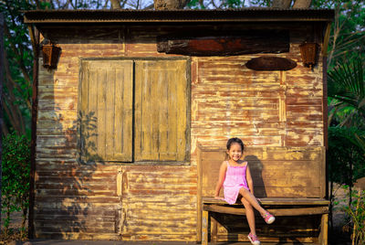 Full length portrait of girl sitting outdoors