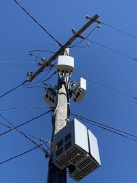 Low angle view of telephone pole against clear sky