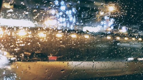 Raindrops on windshield seen through wet window