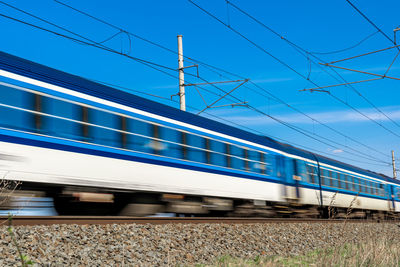 Train on railroad tracks against blue sky