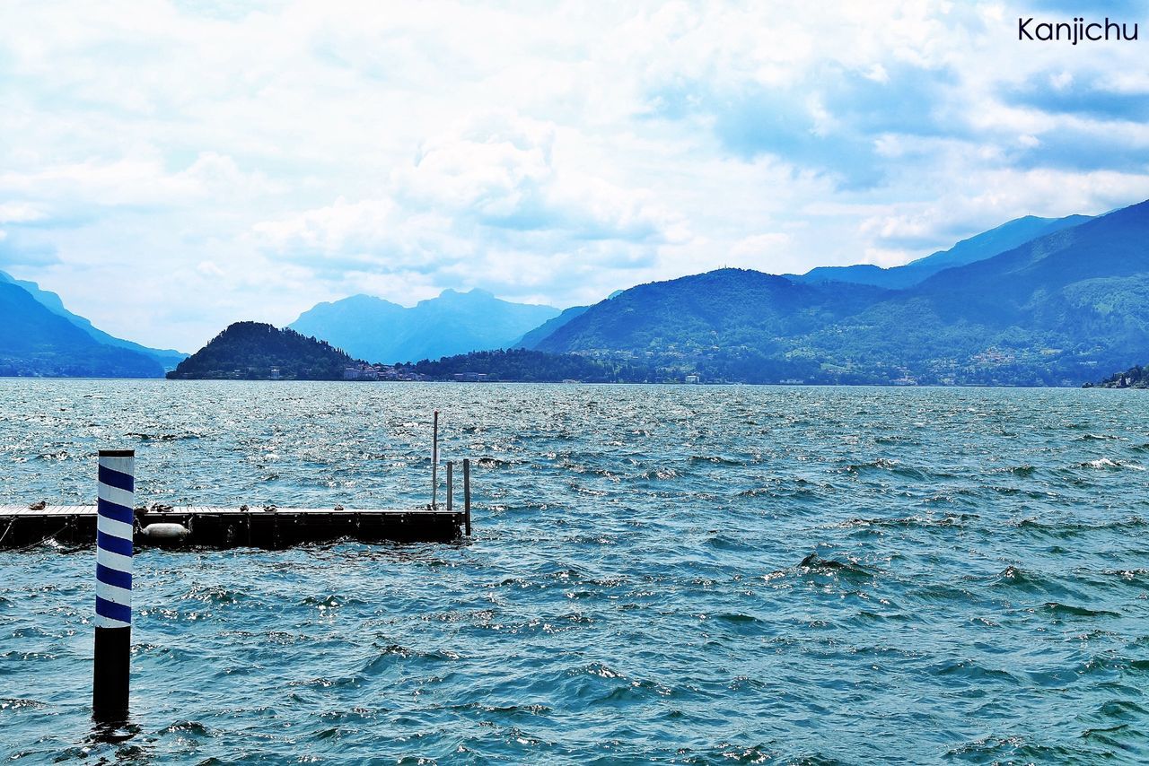 mountain, water, mountain range, waterfront, sky, sea, tranquil scene, rippled, scenics, tranquility, lake, beauty in nature, nature, nautical vessel, cloud - sky, transportation, cloud, boat, idyllic, day