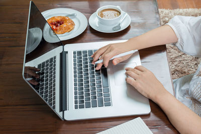 High angle view of woman using laptop on table