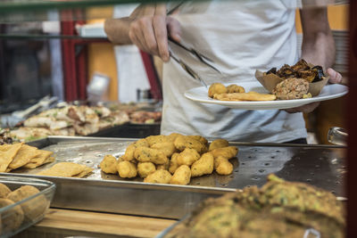 Midsection of man taking food in plate