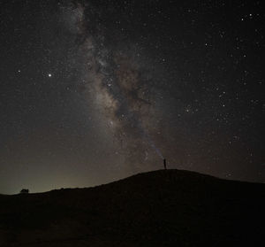 Scenic view of silhouette field against sky at night