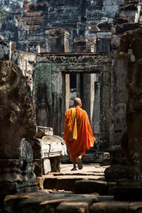 Rear view of monk walking in angkor wat