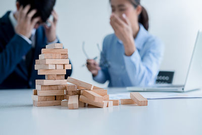 Tensed business colleagues with block removal game at desk in office
