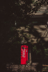 Information sign hanging on tree against building