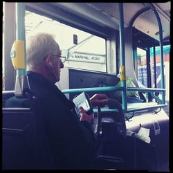 Rear view of woman sitting in bus