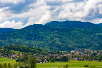 Scenic view of green landscape and mountains against sky