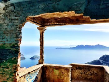 Old ruins by sea against sky