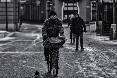 People walking on wet street during rainy season