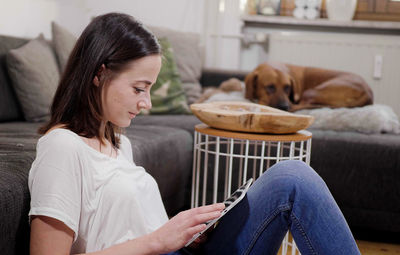 Portrait of young woman using laptop at home