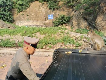 Side view of police standing by monkey