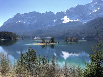 Scenic view of lake by mountains against sky