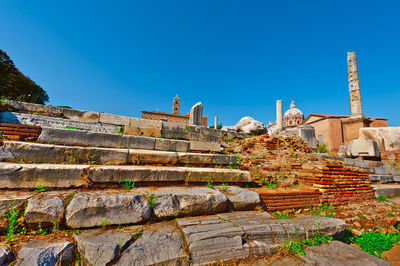 Low angle view of old ruins against clear blue sky