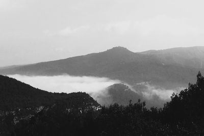 Scenic view of mountains against cloudy sky