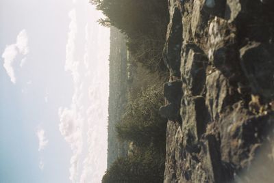 Scenic view of sea by mountains against sky