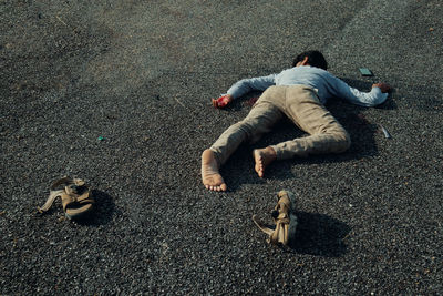 High angle view of man sleeping on road