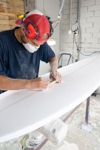 Surfboard modeling workshop - man perfecting the modeling of a surfboard