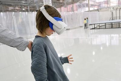 Boy experiencing virtual reality in headset in exhibition center